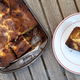 A pan of honeycomb blondies with one serving on a white plate to the side